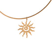 Gold sun-shaped pendant on a gold chain against a white background