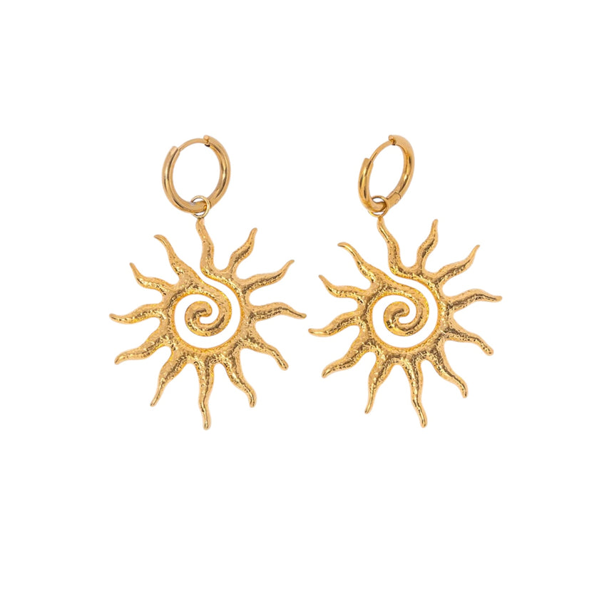Gold sun-shaped earrings on a white background