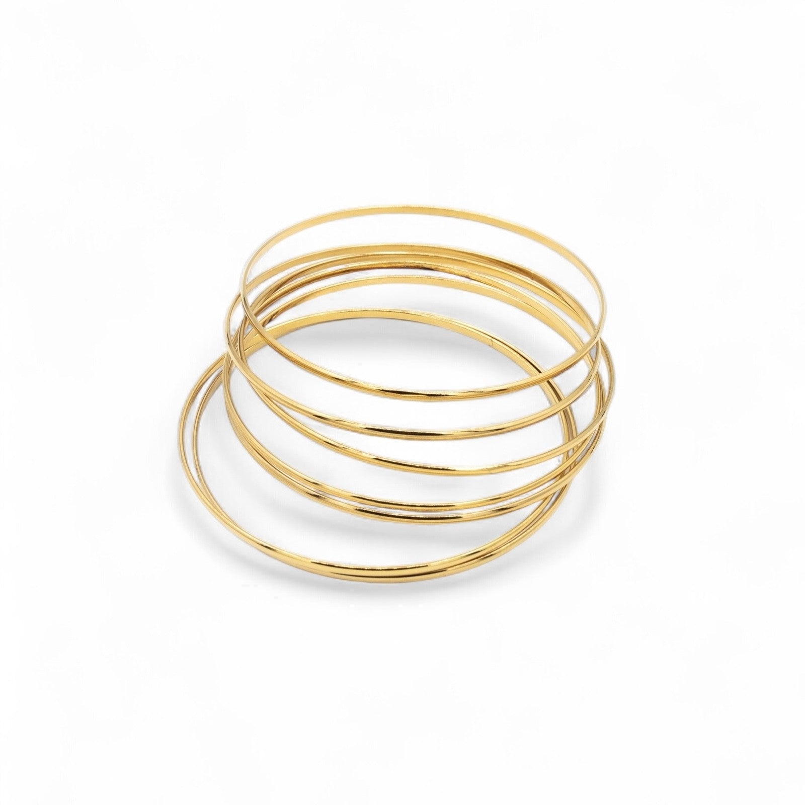Set of 7 smooth gold plated stacking bangles worn together — Bye Bye Baby
