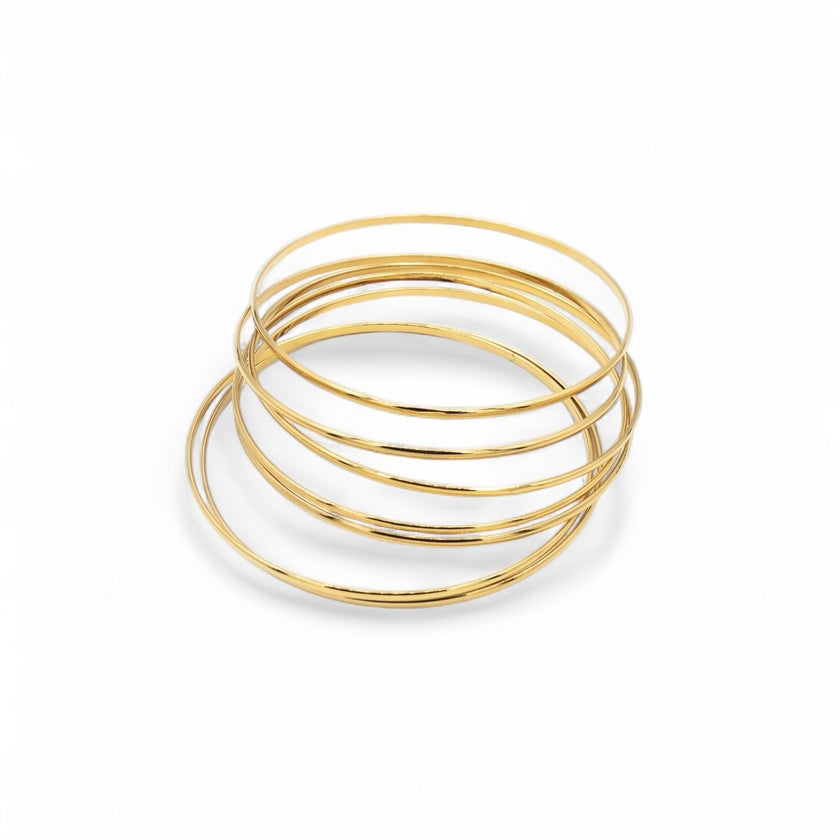 Set of 7 smooth gold plated stacking bangles worn together — Bye Bye Baby
